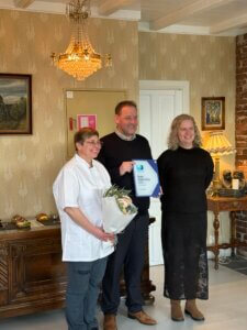 Hilde Eide Helland ved Visit Sunnhordland overrekker blom til Torstein Hatlevik for inspirasjonsprisen til Miljøfyrtårn bedrift 2025. 